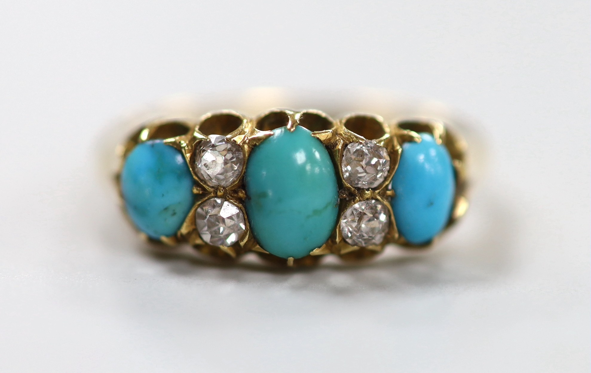 A late Victorian 18ct gold, three stone turquoise and four stone diamond set half hoop ring, size L, gross weight 3.9 grams.